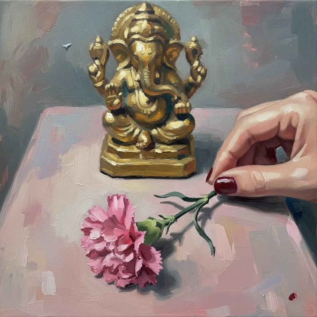 Wilted carnation, blurry Ganesha, and hand with chipped nail polish.