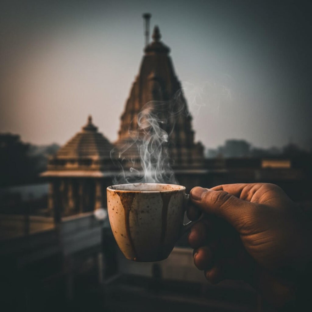 Hand holding a chai cup with a blurry temple spire.