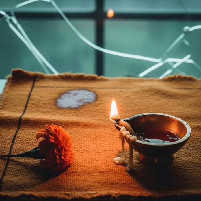 Prayer mat with diya and marigold.