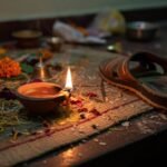 How Guided Prayer Helps You Connect to the Divine Flickering diya, cluttered puja table, sandal nearby.